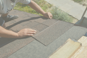 Roofer installing asphalt shingles along roof edge during installation